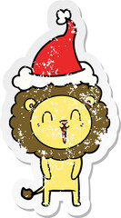 laughing lion distressed sticker cartoon of a wearing santa hat