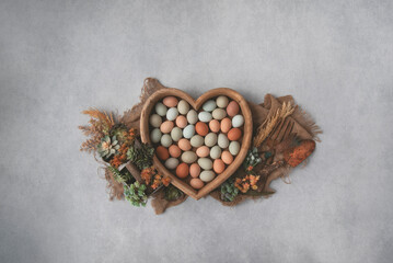 Colorful farm fresh eggs in rustic wooden heart bowl