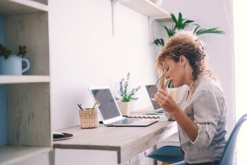 Tired stressed middle age business woman suffering from neckpain working from home office sitting at table. Overworked adult lady massaging neck feeling hurt pain from incorrect posture. Lifestyle