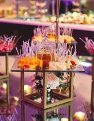 Beautifully decorated banquet catering table with variety of different food snacks, sandwiches, croissants and appetizers on a party event or celebration, delicatessen setting, coffee break