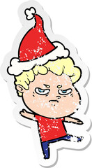 distressed sticker cartoon of a angry man wearing santa hat