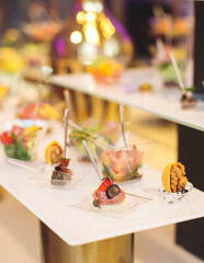 Beautifully decorated banquet catering table with variety of different food snacks, sandwiches, croissants and appetizers on a party event or celebration, delicatessen setting, coffee break