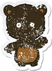 retro distressed sticker of a cartoon black bearcub waving