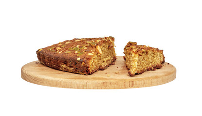 several pieces of homemade sponge cake with nuts on a wooden cutting board.
