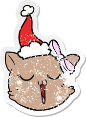 distressed sticker cartoon of a cat face wearing santa hat