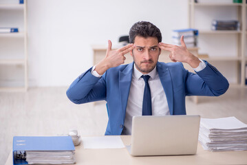 Young male employee and too much work in the office