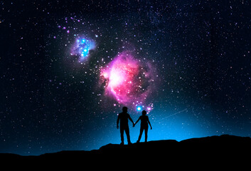 Silhouette of a lovers standing hill and looking on the starry sky with Orion galaxy. Fantasy...
