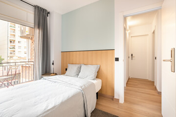 Double bed in the room, next to a large full-wall window with access to a balcony and a view of...