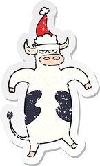 distressed sticker cartoon of a bull wearing santa hat