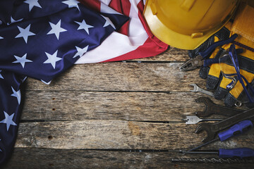 US flag, set construction tools and protective helmet wooden background.Concept for Labor Day first May.