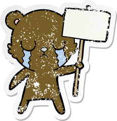 distressed sticker of a crying cartoon bear with sign