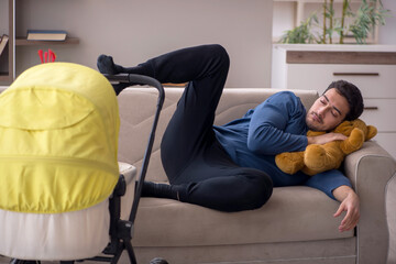 Young male contractor looking after baby at home