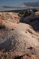 Quartz open cast mine at sunset. View of the white quartz hill with beautiful sundown colors.