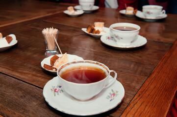 porcelain cups with tea and natural apple pastille on a wooden table in a cafe