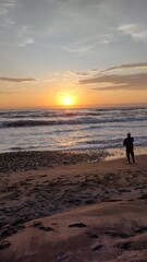 Fototapeta na wymiar fisherman on the beach at sunset