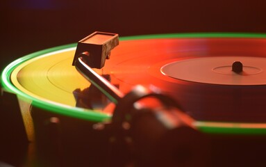 Colored vinyl record in the dark on turntable mixer dj party mixer sound recording and music...