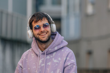 young man with headphones and sunglasses on the street