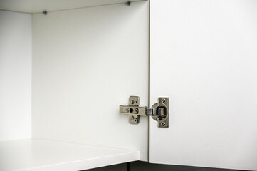 Stainless furniture hinge for cabinet or closet doors. Furniture assembly - obrazy, fototapety, plakaty