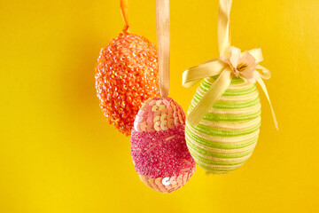 Hanging Easter eggs on a yellow background. Easter celebration. Easter background.