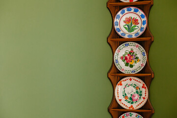 Handmade plates with a pattern stand on a stand on a green background