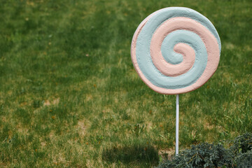 Birthday decor, candies, ice cream, cheesecake on a background of grass near the house.