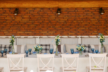 A table is set in a wooden gazebo near a house outside the city. Birthday decor.
