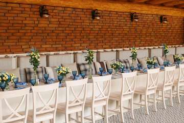 A table is set in a wooden gazebo near a house outside the city. Birthday decor.