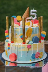 Bright festive cake for the birthday on the background of a grass work