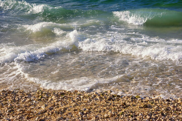 Waves on a pebble beach on sunny windy day. Adriatic Sea, Montenegro