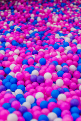 Fototapeta na wymiar Background, closeup texture of colored, multi-colored round plastic small balls on the playground for children's games. Photo, top view, copy space.