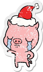 distressed sticker cartoon of a pig crying wearing santa hat