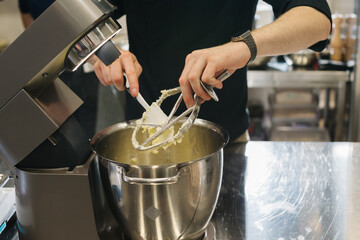 Making macarons. A silver kitchen table mixer kneads the dough for macarons.
