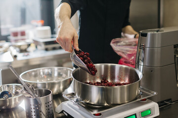 Close up. A chef weighs cherries for baking a fruit pie or other desserts.