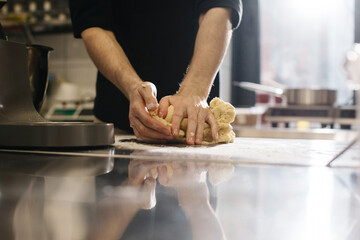 Close up. The cook kneads the dough with his hands, making macaroons or cakes.