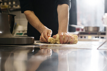 Close up. The cook kneads the dough with his hands, making macaroons or cakes.
