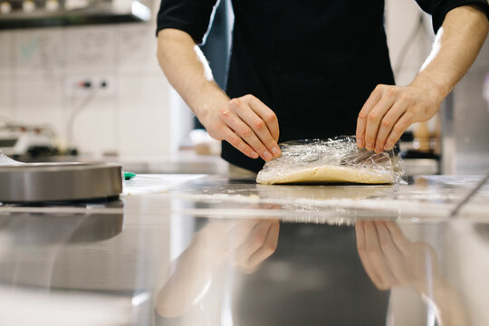Close up. The cook wraps the dough in cling film, making macaroons or cakes. - Powered by Adobe