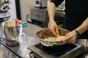 The chef works in the kitchen. The process of making dough for macaroons.