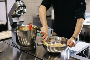 The chef works in the kitchen. The process of making dough for macaroons.