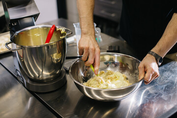 The chef works in the kitchen. The process of making dough for macaroons.