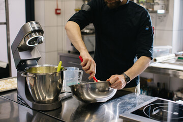 The chef works in the kitchen. The process of making dough for macaroons.