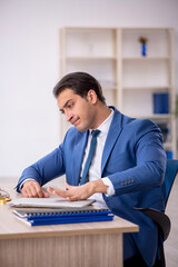 Fototapeta premium Young male employee working in the office