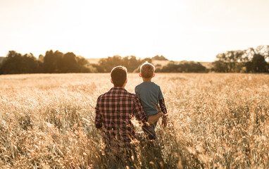 Father and son out in a field enjoying nature 
