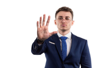 Man in a suit and tie makes a stop gesture with his hand showing his palm. On a white isolated background. 