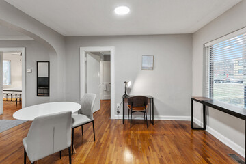 White apartment with wide open spaces, hardwood flooring and modern furniture. Used as a short term rental. 