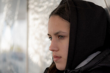 Close-up side face of girl with green eyes and serious or sad facial expressions, looking away. Copy space for text insertion.