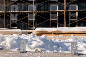 Close-up of metal fasteners in the foundation of a modular home against the background of a...