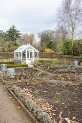 greenhouse and a dormant kitchen garden during a british winter,planters,plant pots