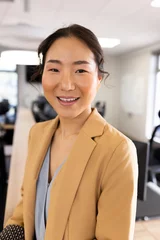 Foto op Plexiglas Aziatische plekken Vertical image of happy asian businesswoman looking at camera in office