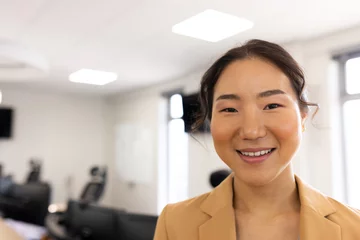 Foto op Plexiglas Aziatische plekken Happy asian businesswoman looking at camera in office