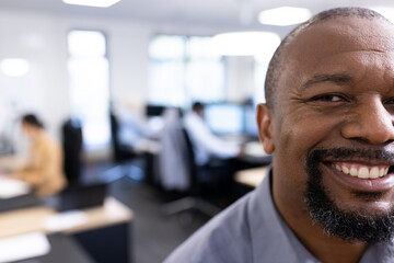 Happy african american businessman looking at camera in office